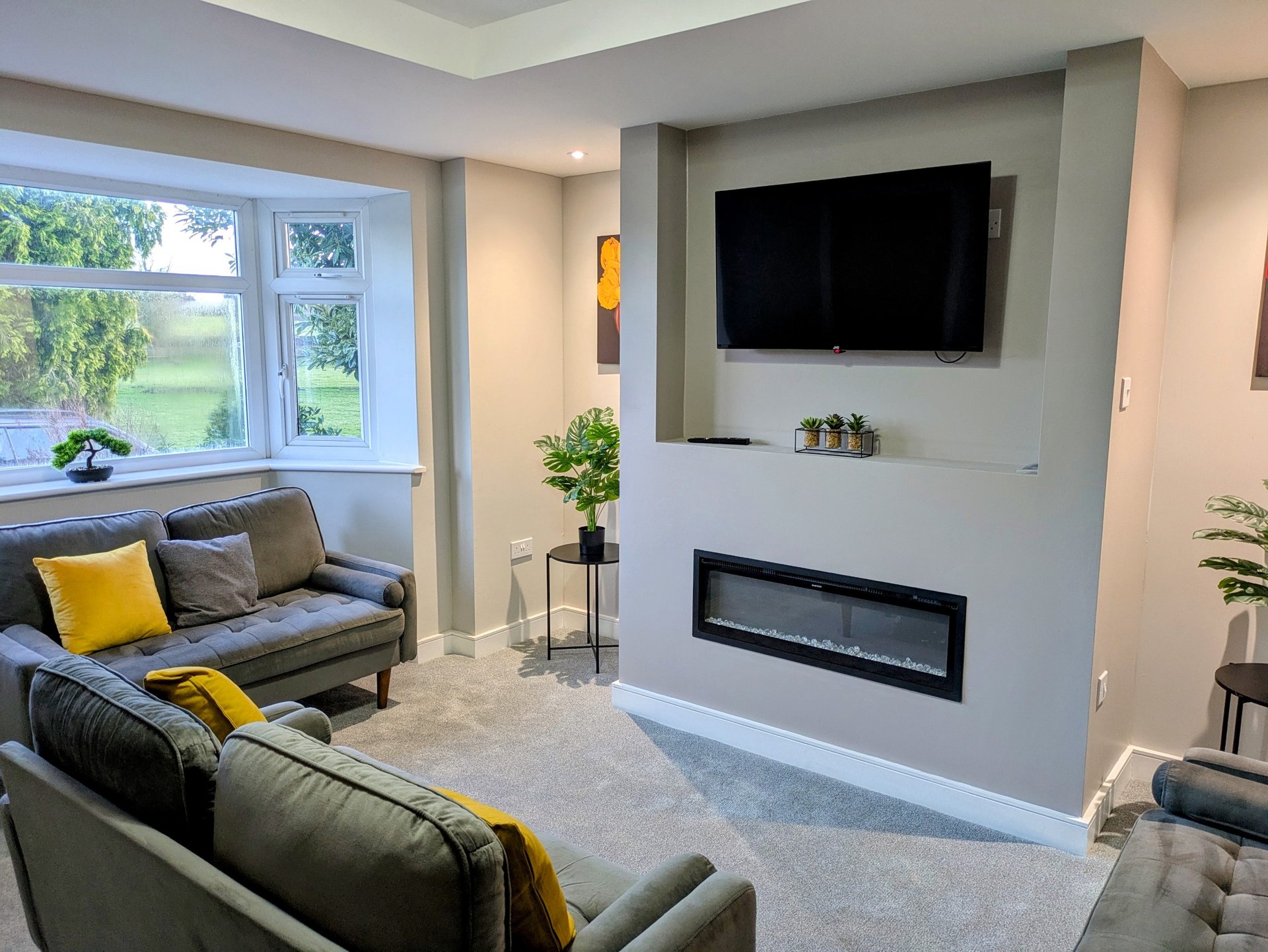 A comfortable, well-presented lounge with plenty of seating, a large Smart TV and modern electric fireplace. A relaxing space for guests to unwind after a busy working day.