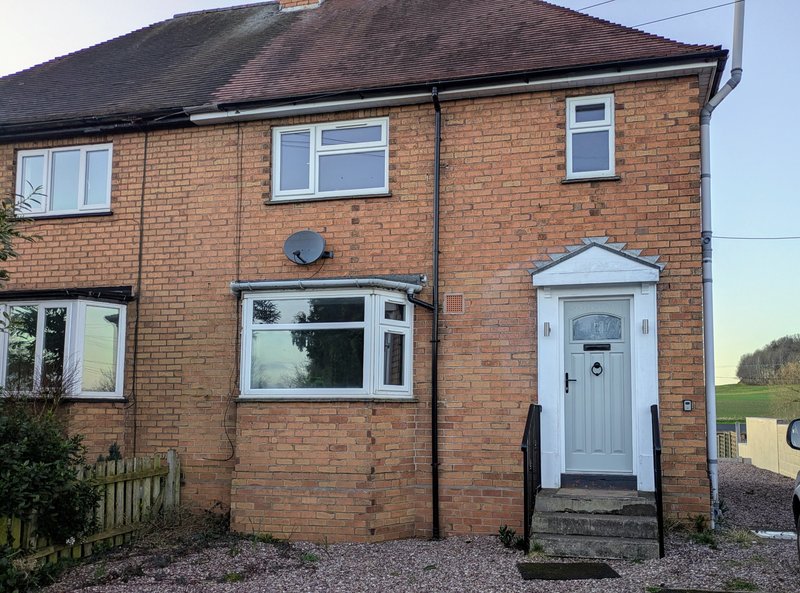 Exterior view of the property, with private entrance, gravelled frontage and surrounding countryside views.
