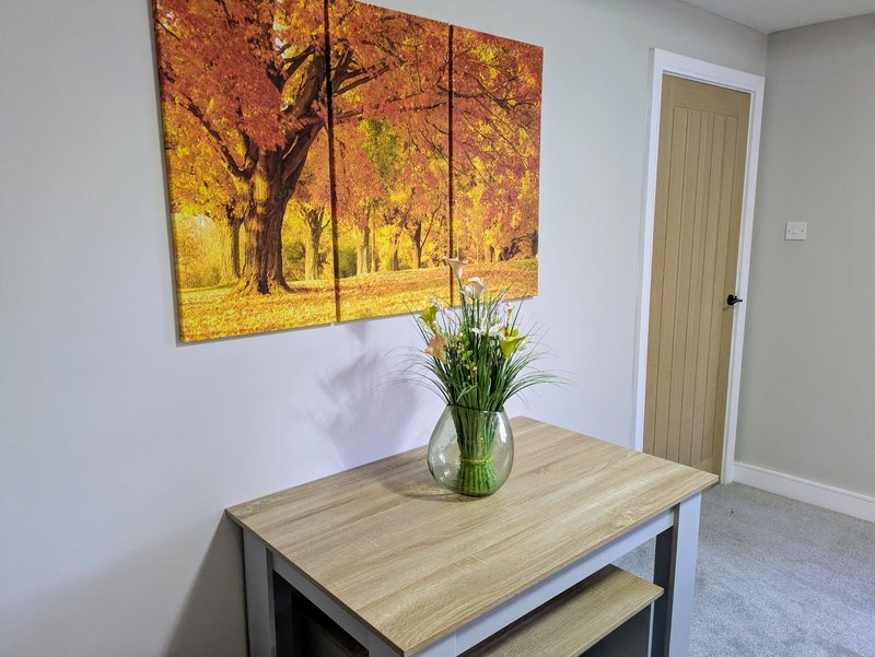 Bright interior space with dining table, benches and additional stools, providing comfortable seating for up to 6 guests.