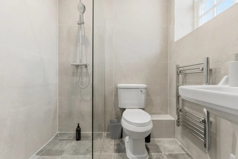 Modern bathroom with walk-in shower, toilet, sink and heated towel rail