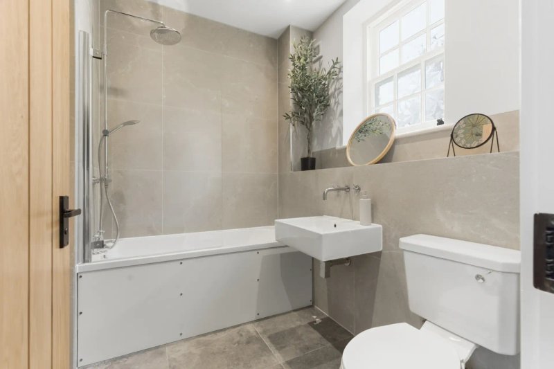 Modern bathroom with bathtub, shower enclosure, white toilet and sink