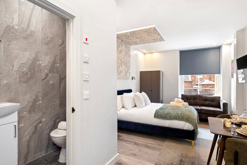 Studio bedroom with double bed, ensuite bathroom, desk area and kitchenette