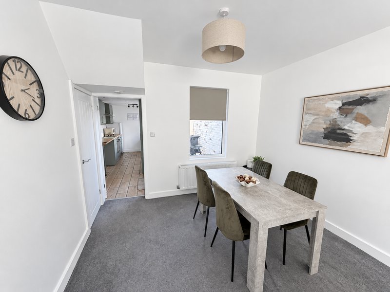Modern dining room with marble table, grey chairs, wall clock and pendant lamp