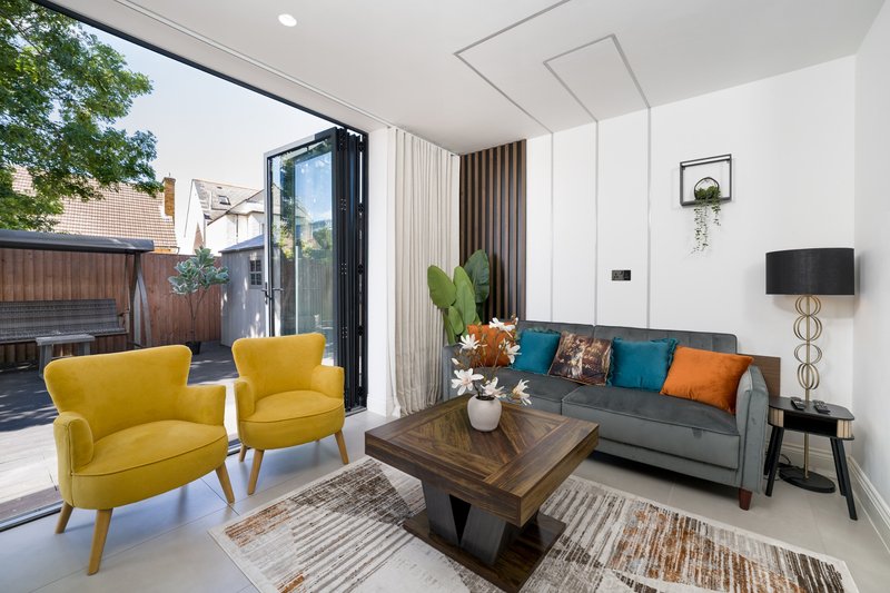 Modern living room with yellow armchairs, gray sofa, wooden coffee table and patio doors