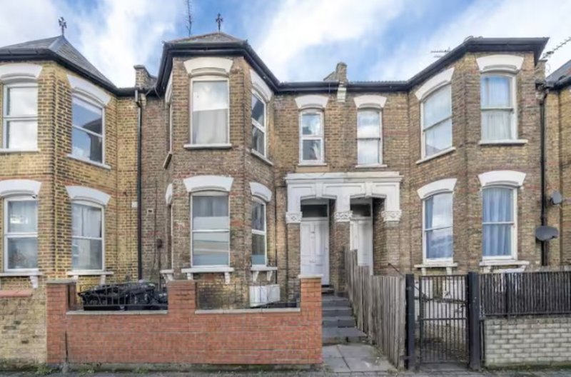 Brick Victorian terraced houses with sash windows, front gardens and black metal fencing