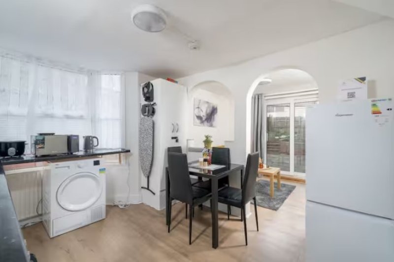 Open-plan kitchen and dining area with washing machine, dining table, and appliances