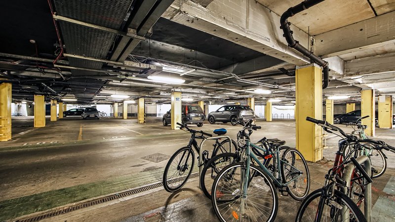 Underground parking garage with bicycles parked and yellow support columns