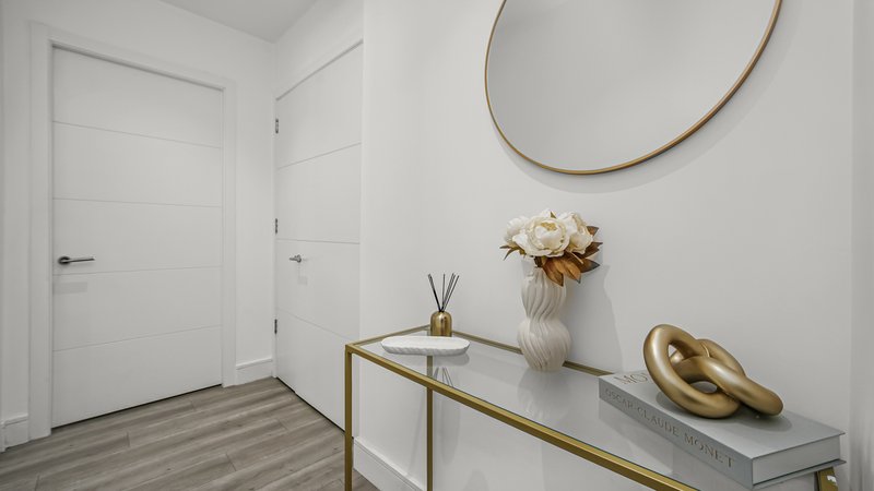 Modern entryway with white doors, console table, mirror, dried flowers and decorative objects