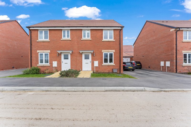 Red brick semi-detached houses with white doors and windows, driveway and parking area
