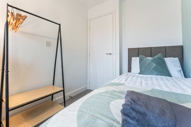 Bright bedroom with double bed, four-poster frame, and white wardrobe door