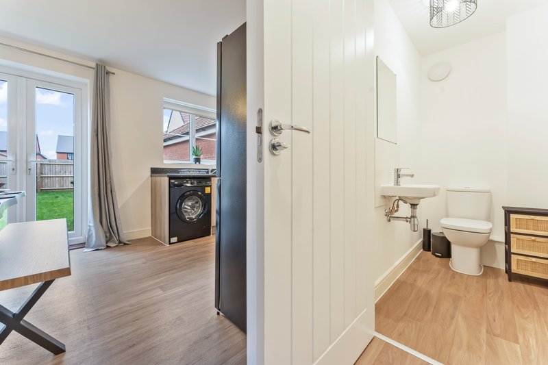 Open-plan living area with kitchen, washing machine, bathroom entrance and garden access