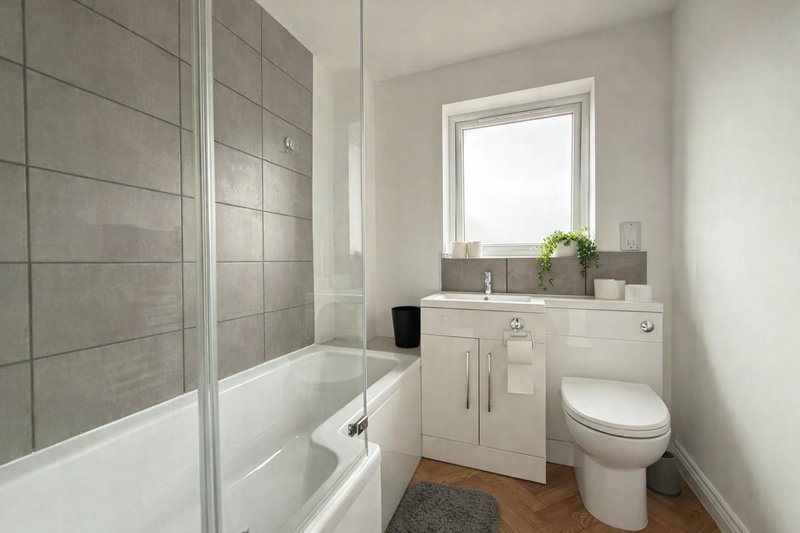 Modern bathroom with white vanity, toilet, bathtub, shower enclosure and window
