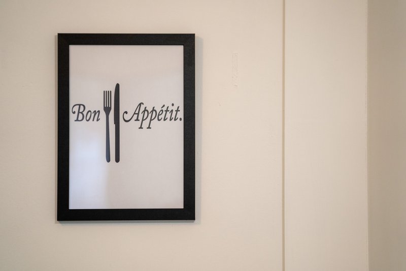 Framed wall art with 'Bon Appétit' text and fork and knife illustration