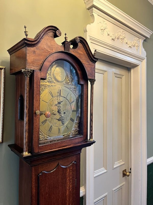 Hallway with traditional wooden grandfather clock and white panelled door