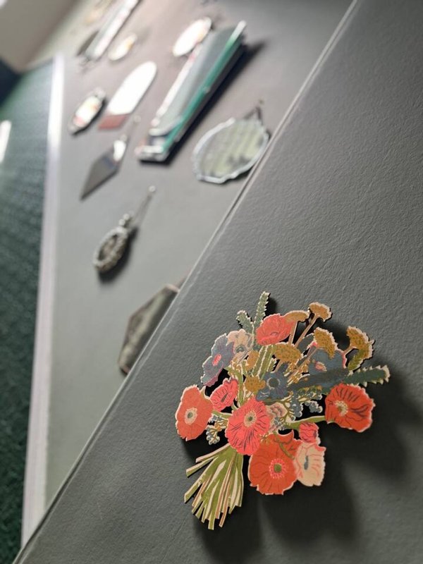 Gray wall with decorative floral arrangement and mounted art pieces