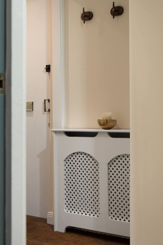 Bathroom vanity with white cabinet, black faucet handles, and woven basket above sink