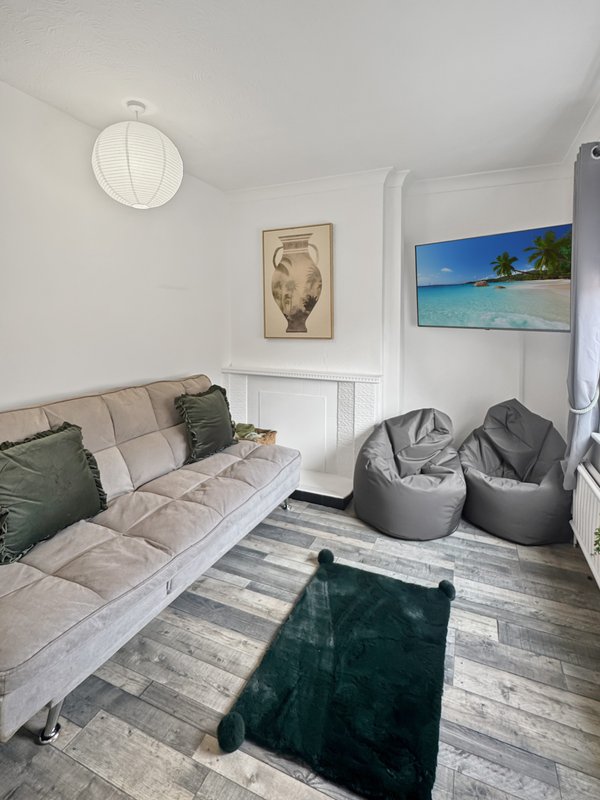 Bright studio room with upholstered daybed, bean bags, wooden floor and wall art