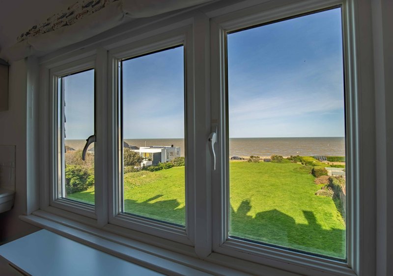 Large windows with rural countryside views, green fields and distant buildings visible