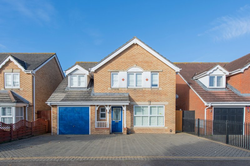 Modern brick detached house with blue garage door, driveway and front garden
