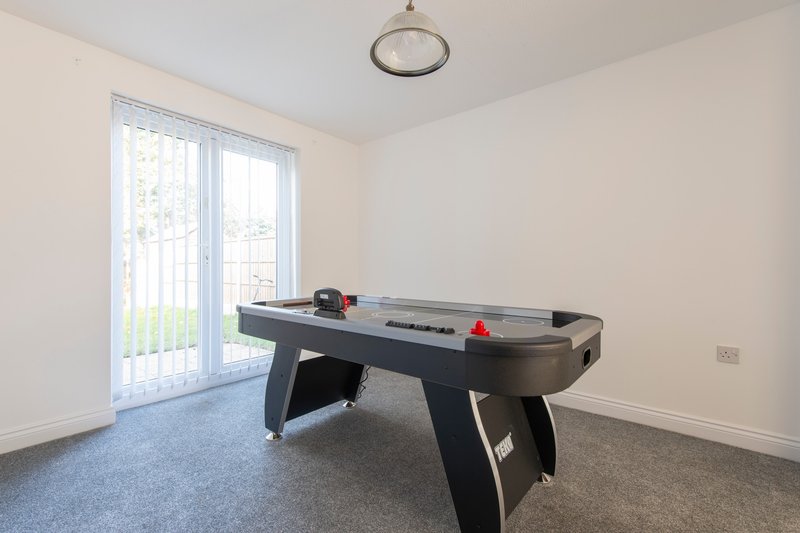 Recreation room with air hockey table, glass patio doors and neutral carpeting