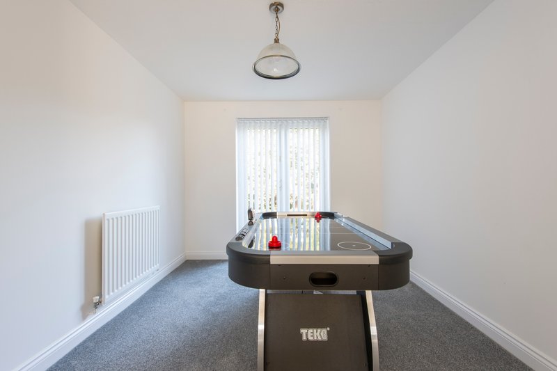 Games room with foosball table, radiator, pendant light and vertical blinds