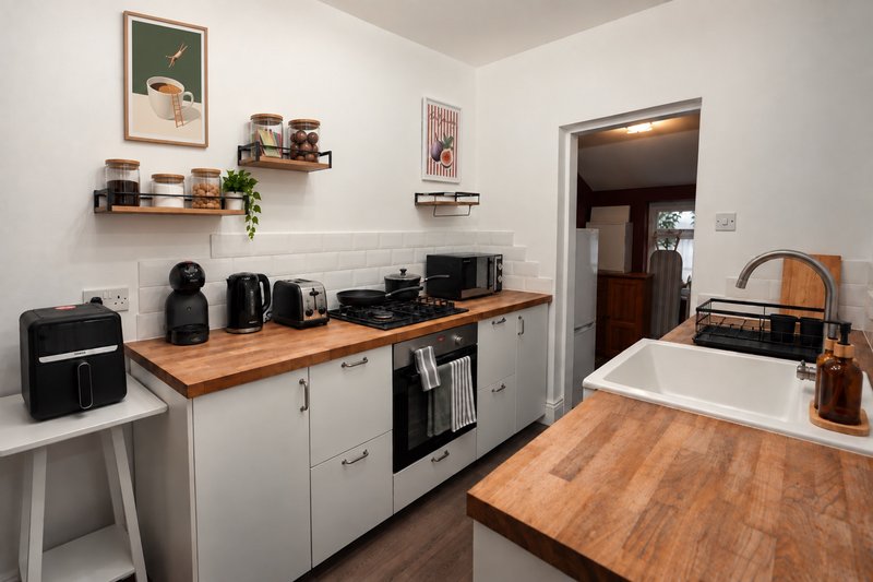 Modern kitchen with white cabinetry, wooden countertops, stainless steel appliances and shelving