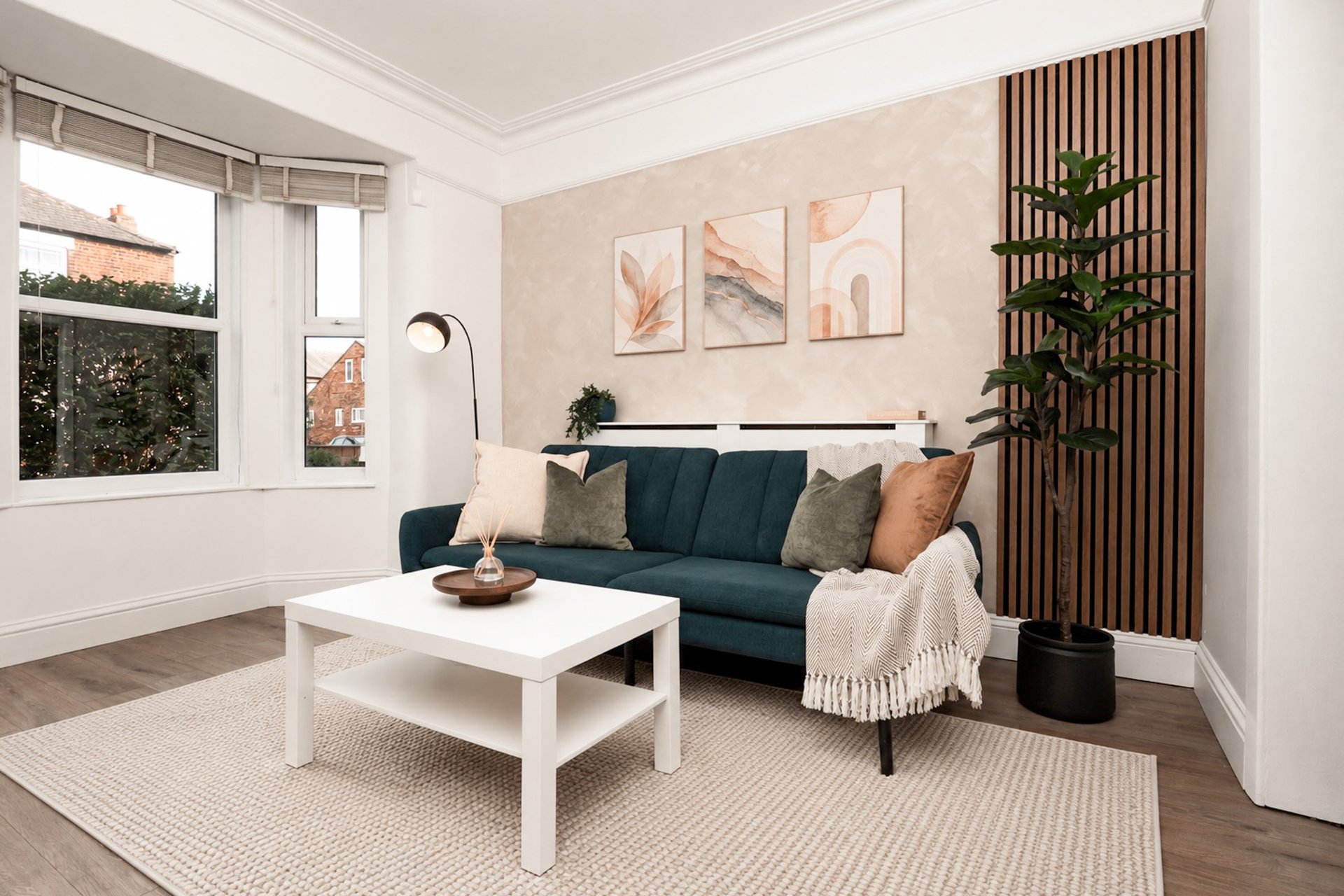 Bright living room with dark blue sofa, white coffee table, and decorative wall art