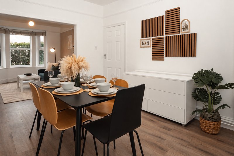 Modern dining room with black table, tan and black chairs, place settings, and decorative wall panels