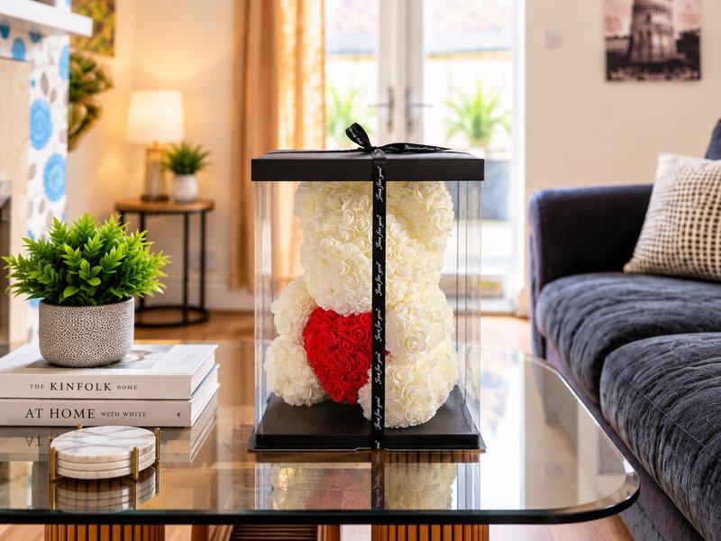 Living room with sofa, coffee table, decorative bear arrangement, books and potted plants