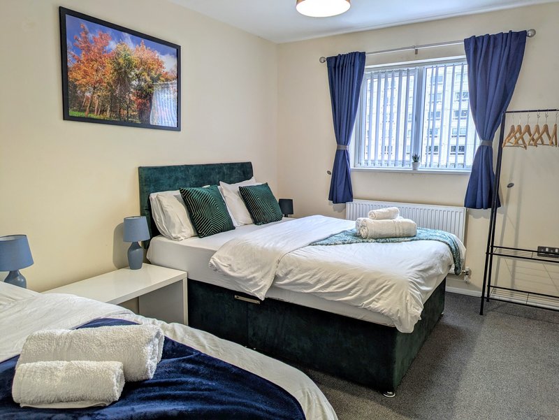 A comfortable and spacious bedroom featuring one double bed and one single bed, along with a private ensuite shower room, making it ideal for contractors sharing accommodation.