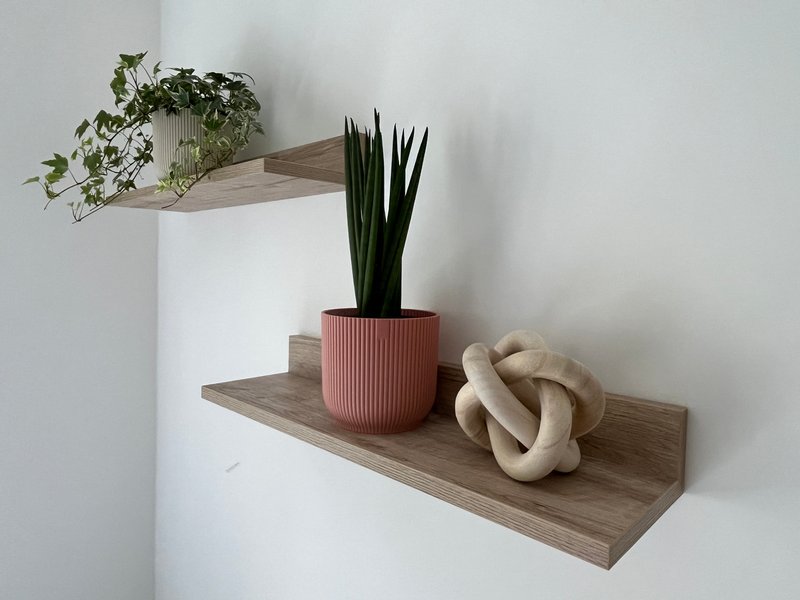 Wooden wall shelves decorated with potted plants, ceramic sculpture and trailing greenery