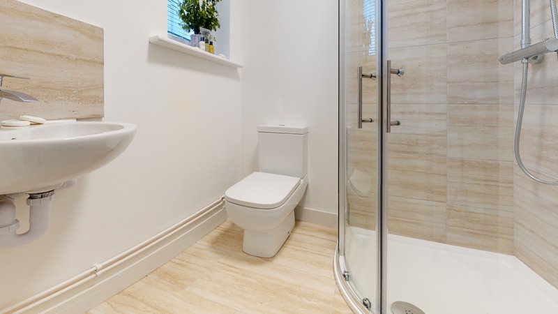 Bathroom with toilet, wall-mounted sink, shower enclosure and window