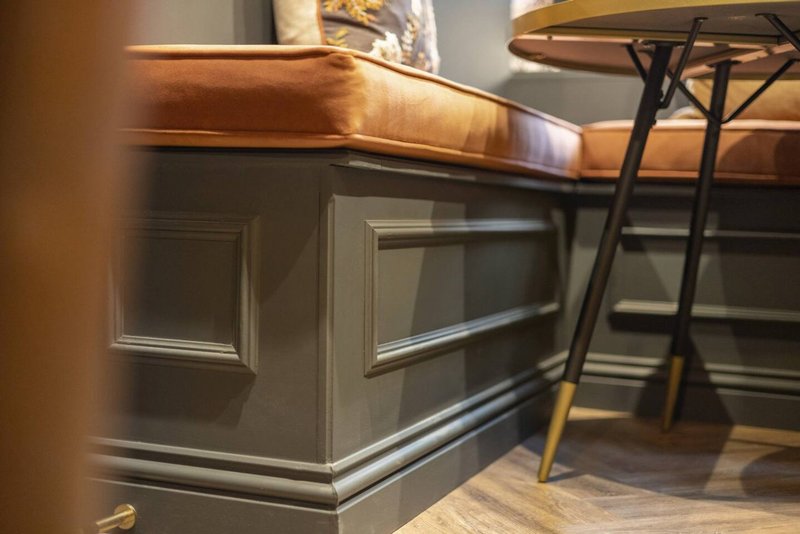 Kitchen island with dark cabinetry, copper countertop, and bar seating area