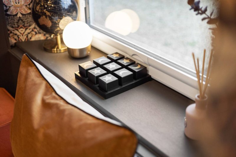 Windowsill with decorative lamps, puzzle cube, and potted plant near leather chair