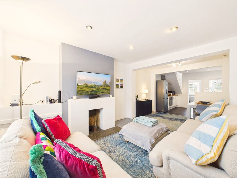 Modern studio apartment with sofa, fireplace, TV, bedroom area and open-plan layout