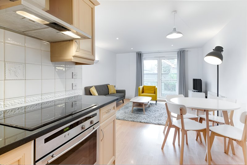Open-plan modern apartment with kitchen, dining area and lounge with yellow accents