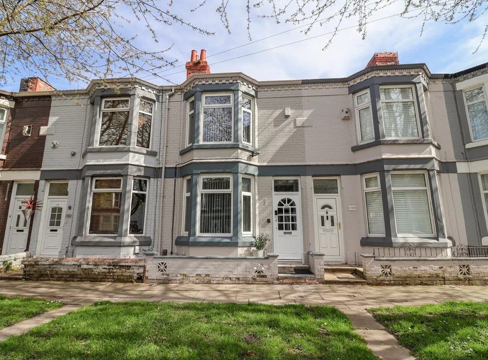 Exterior of traditional terraced house with bay windows, front garden and entrance door