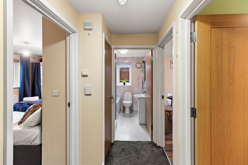 Hallway with multiple doorways leading to bedroom, bathroom and other rooms