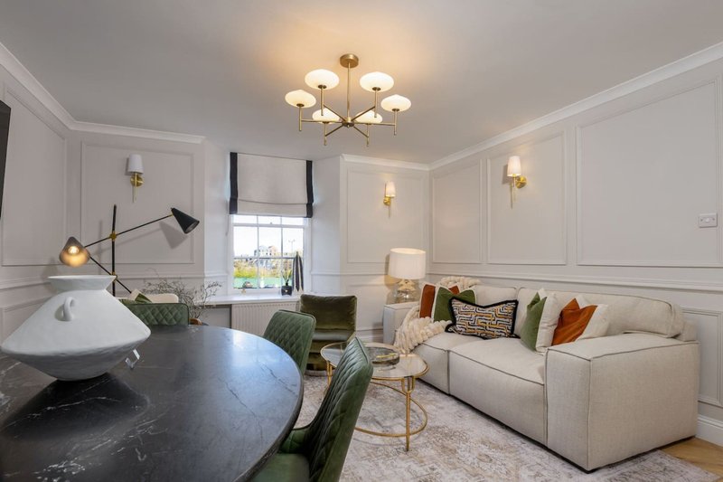 Modern living room with cream sofa, marble dining table, pendant lighting and panelled walls