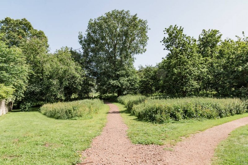Garden grounds with gravel pathways, manicured lawn, mature trees and hedges