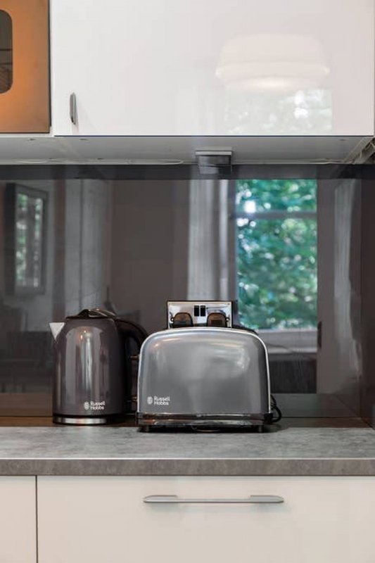 Kitchen countertop with black kettle, toaster, and window with garden view
