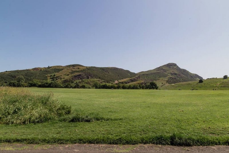 Rolling green countryside with distant hills and clear blue sky