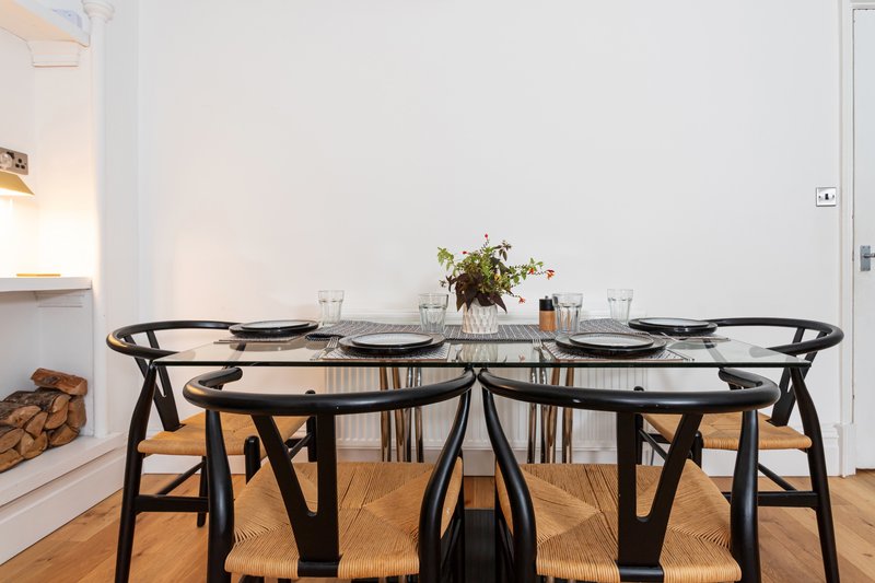 Modern dining room with black table, wishbone chairs, and place settings
