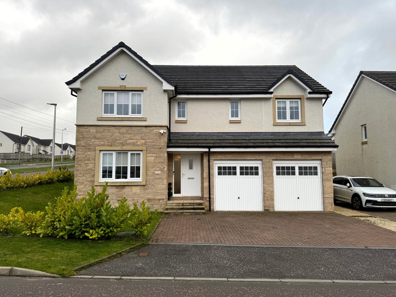 Modern two-storey detached house with stone and render exterior, double garage, driveway and landscaped front garden