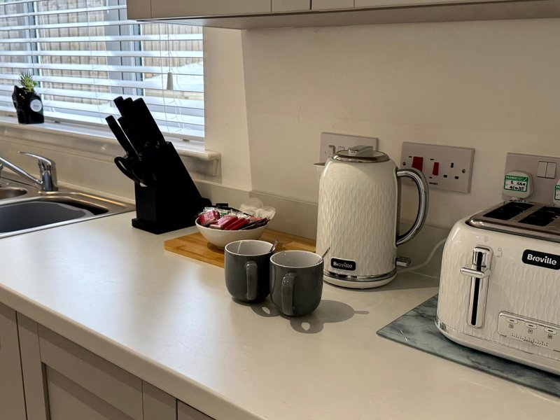 Modern kitchen counter with appliances, knife block, kettle, toaster and window view