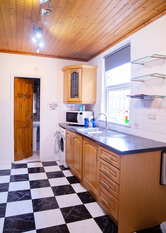 Kitchen with wooden cabinets, black and white checkered floor, and wooden ceiling