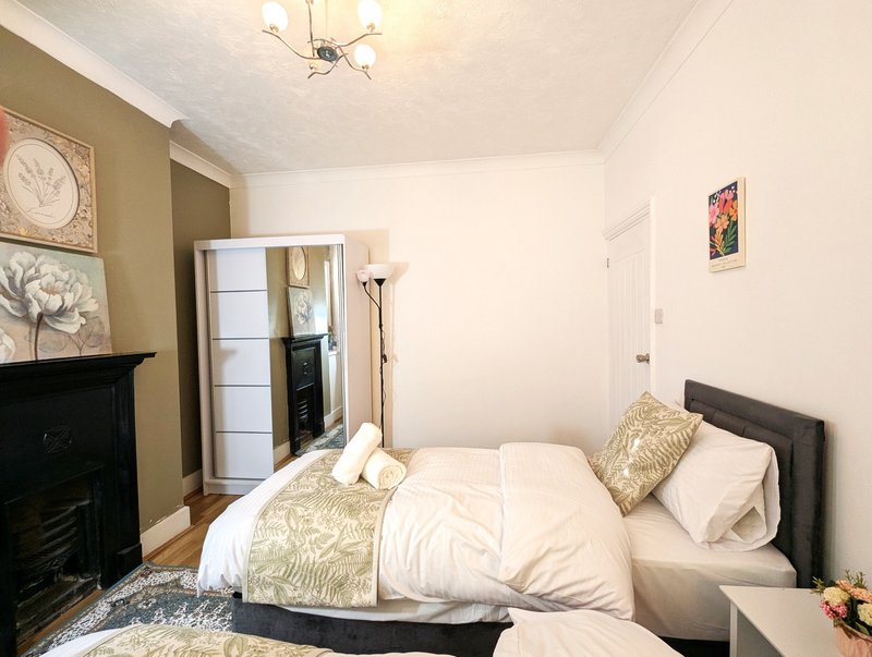 Bedroom with double bed, fireplace, wardrobe and framed wall art