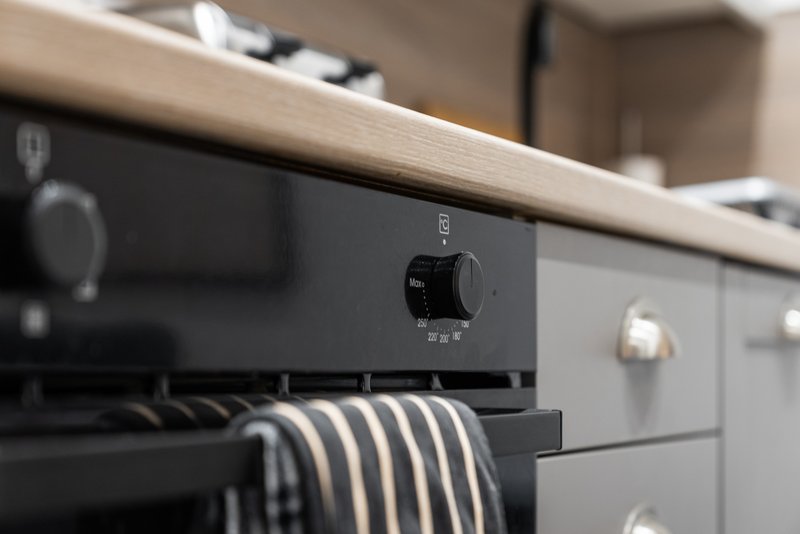 Modern kitchen with black oven, striped kitchen towel, and wooden countertop