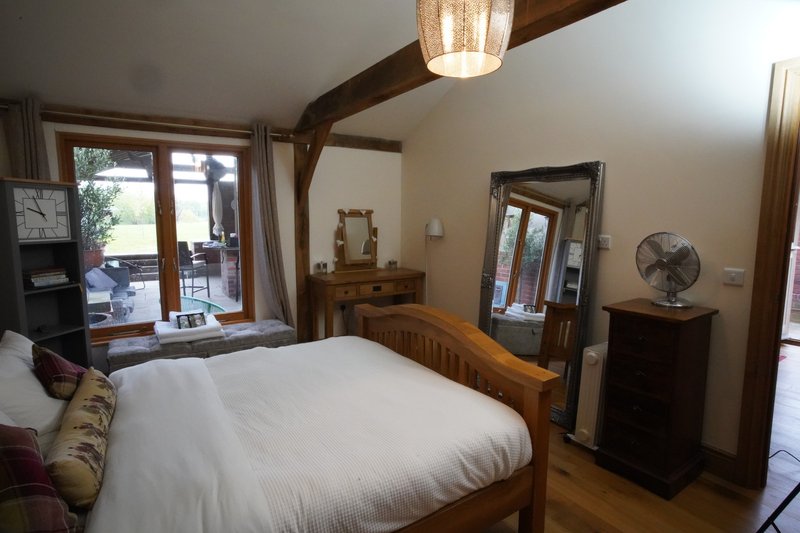 Spacious, comfortable double bedroom with quality bedding, plenty of natural light and attractive exposed beams, providing a relaxing space to unwind after a busy working day.