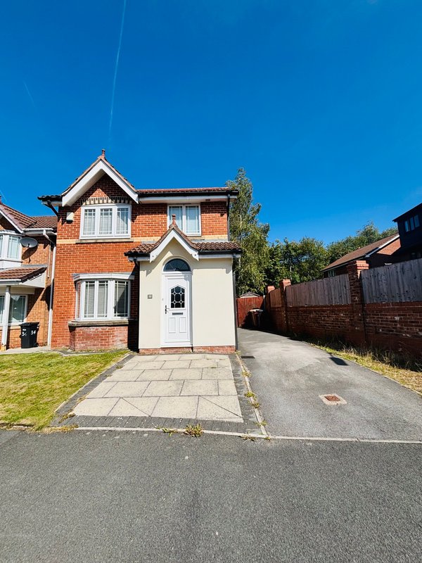 Brick semi-detached house with driveway, front garden and clear blue sky